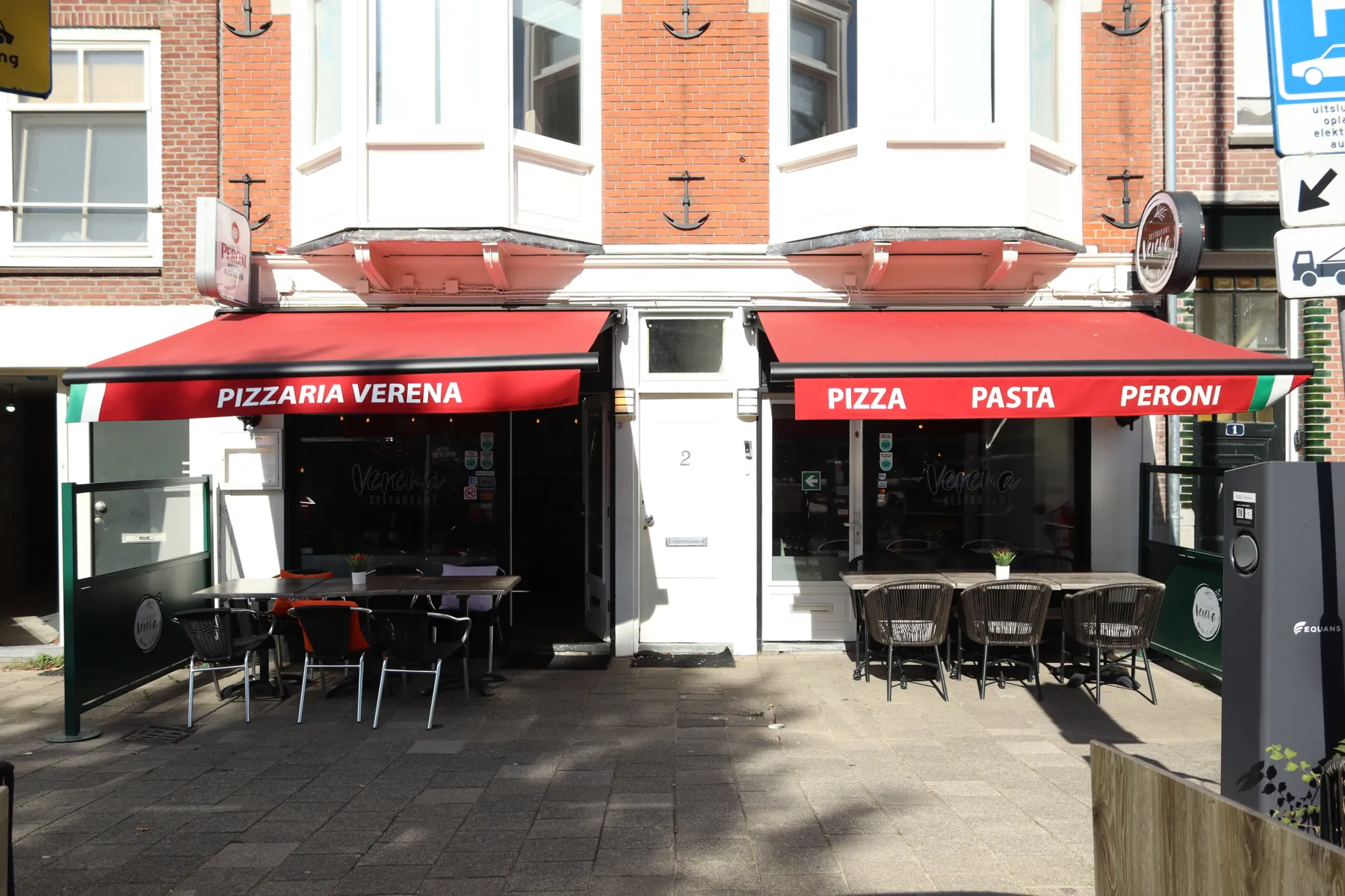 Het terras op het plein met uitgeklapte rode zonneschermen