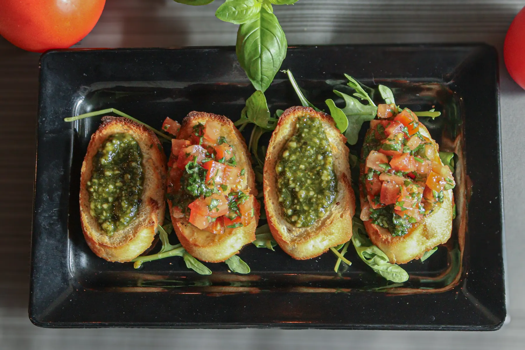 Bruschetta met tomatensalade en pesto, van bovenaf gefotografeerd