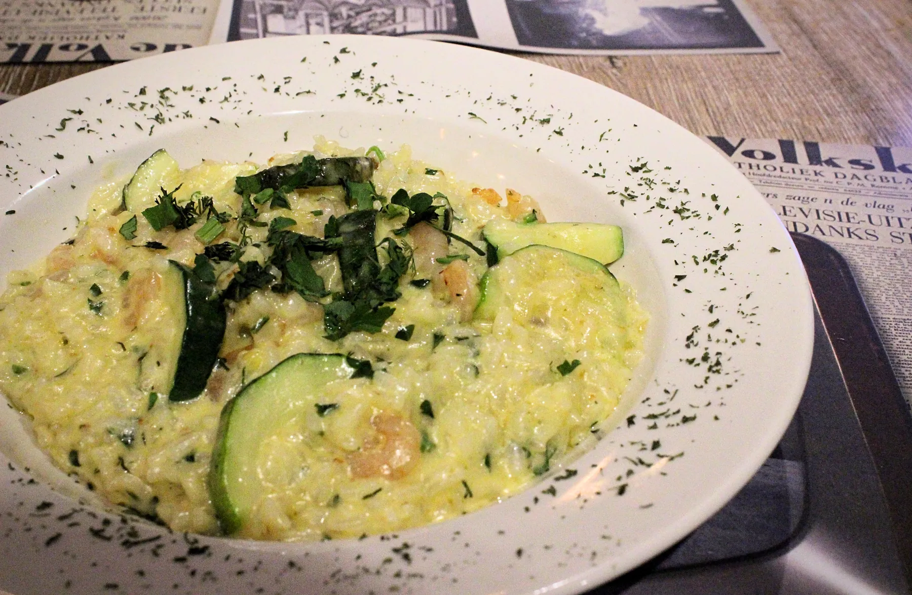 Risotto met garnalen en courgette, bestrooid met peterselie