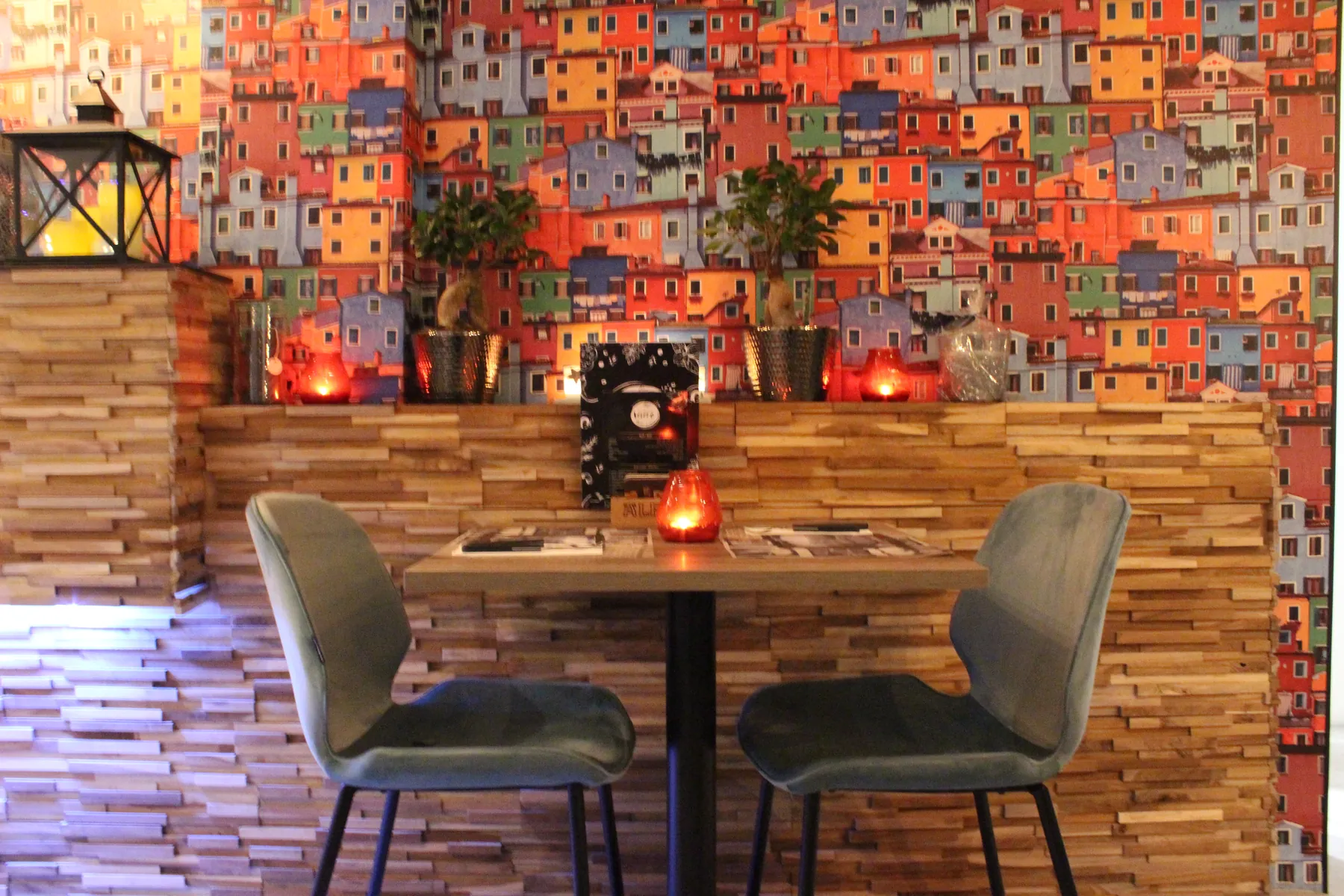 Een gedekte tafel voor twee bij de houten wand, in warm avondlicht